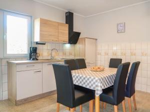 a kitchen with a table and chairs and a kitchen with a sink at Apartment Mira by Interhome in Rab