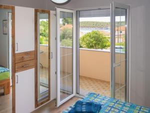 a bedroom with glass doors with a view of a balcony at Apartment Mira by Interhome in Rab