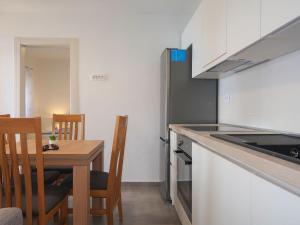 a kitchen with a wooden table and a kitchen counter at Apartment Bajadera by Interhome in Jablanac +29 photos