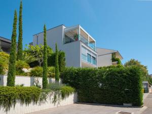 a house with green hedges in front of it at Apartment Deluxe Bellissima by Interhome in Crikvenica