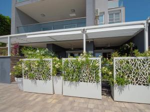 a group of plants in white pots in front of a building at Apartment Deluxe Bellissima by Interhome in Crikvenica +31 photos