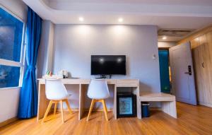 een kamer met een bureau met 2 stoelen en een televisie bij Sapphire Hotel Silom Bangkok in Bangkok