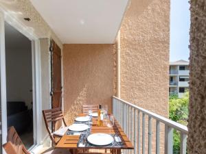 balkon z drewnianym stołem i krzesłami w obiekcie Studio Les Aigues Marines-63 by Interhome w mieście Saint-Cyr-sur-Mer