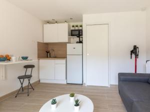 kuchnia i salon z kanapą i stołem w obiekcie Studio Les Aigues Marines-63 by Interhome w mieście Saint-Cyr-sur-Mer