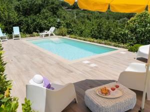 basen z krzesłami, stołem i parasolem w obiekcie Villa Villa Bougainvillea by Interhome w mieście Trevignano Romano