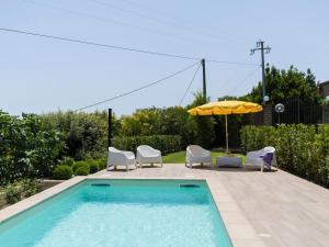 basen z krzesłami i parasolem w obiekcie Villa Villa Bougainvillea by Interhome w mieście Trevignano Romano