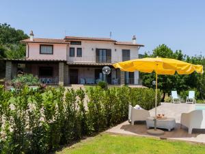 patio z parasolem i krzesłami oraz dom w obiekcie Villa Villa Bougainvillea by Interhome w mieście Trevignano Romano
