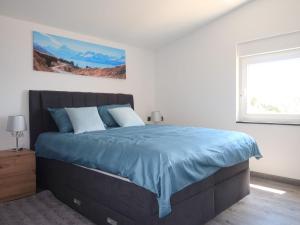 a bedroom with a bed with blue sheets and a window at Holiday Home Emili & Elias by Interhome in Karlobag