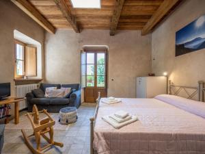 a large bedroom with a large bed and a couch at Apartment L'appartamento del Monastero by Interhome in Dronero