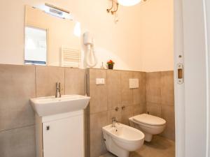 a bathroom with a sink and a toilet and a mirror at Apartment More e Lamponi by Interhome in Avane
