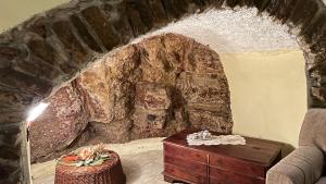 Zimmer mit einer Steinmauer und einem Holztisch in der Unterkunft La Cantina Di Nonno Ciccio in Fuscaldo