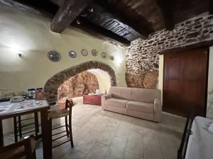 ein Wohnzimmer mit einem Sofa und einer Steinmauer in der Unterkunft La Cantina Di Nonno Ciccio in Fuscaldo