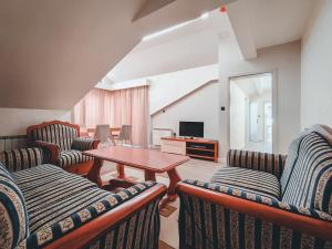 a living room with couches and a table and a television at Motel Almy in Zenica