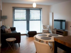 een woonkamer met een bank en een tafel bij Pass the Keys Lovely New 2-Bed SEC, Hydro, Finnieston with Parking in Glasgow