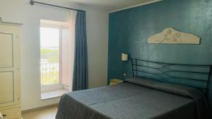 a blue bedroom with a bed and a window at Hotel Boutique Il Castellino Relais in Vieste