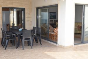 a black dining room table and chairs on a patio at Vila Oceânica 1 in Figueira da Foz