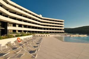 a resort with chairs and a swimming pool at Grand Hotel View in Postira