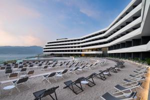 a row of chairs on a beach next to a building at Grand Hotel View in Postira