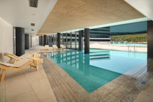 a large swimming pool with chairs in a building at Grand Hotel View in Postira