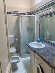 een badkamer met een wastafel, een toilet en een douche bij Appartamento incantevole: Numana in Numana