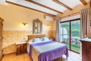 a bedroom with a bed and a large window at Hotel Finca Fabiola in Finestrat
