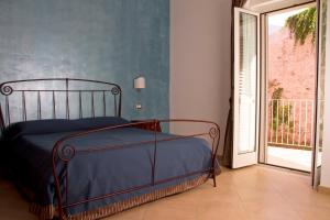 una camera con letto e porta di accesso a un balcone di Hotel Boutique Il Castellino Relais a Vieste