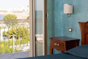 una camera con letto e vista su un balcone di Hotel Boutique Il Castellino Relais a Vieste