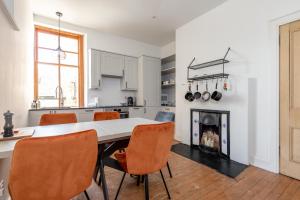 een keuken met een tafel en stoelen en een open haard bij Oakwood House - Sleeps 6 - St Andrews in St Andrews
