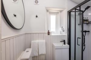 een witte badkamer met een wastafel en een spiegel bij Oakwood House - Sleeps 6 - St Andrews in St Andrews