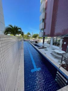 a swimming pool in front of a building at 3 SUITES Vista Mar - WI-FI, PISCINA, SAUNA, ACADEMIA, GARAGEM 2 CARROS in Ilhéus