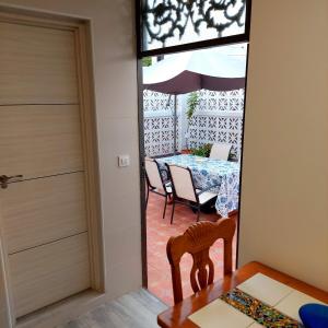 Habitación con mesa, sillas y puerta en Villa Puerto Santa María, en El Puerto de Santa María