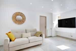 Biały salon z kanapą i telewizorem w obiekcie Cosy apartment 4P-1BR Flandre-Crimée w Paryżu