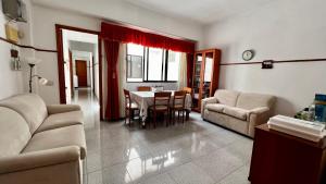 een woonkamer met een bank en een tafel en stoelen bij Central, quiet and comfortable room, breakfast in Las Palmas de Gran Canaria