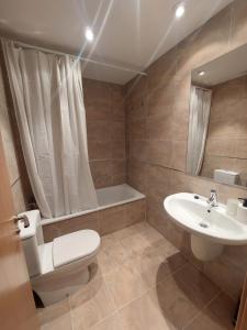 a bathroom with a toilet and a sink and a tub at BRICIA APARTAMENTO 16 in Llanes