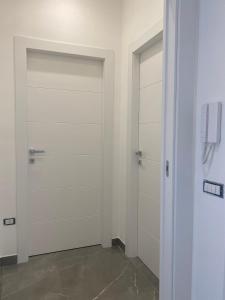 twee witte garagedeuren in een kamer met een telefoon bij Casa del Credente in Madonna dellʼArco
