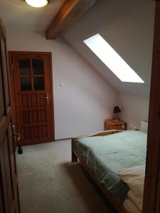 ein Schlafzimmer mit einem Bett und einem Dachfenster in der Unterkunft PAN Dom Pracy Twórczej w Wierzbie in Wierzba