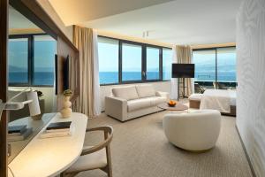 uma sala de estar com uma cama, um sofá e uma mesa em Grand Hotel View em Postira