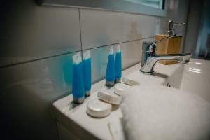 ein Waschbecken mit drei blauen Zahnbürsten drauf in der Unterkunft JBHotels Apartament Premium in Stettin