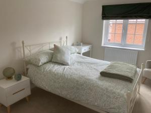 a bedroom with a white bed and a window at Mill Meadows in Portskewett