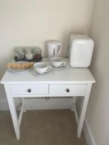 a white table with bowls and a toaster on it at Mill Meadows in Portskewett