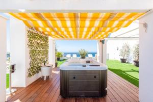 a patio with an outdoor kitchen with a yellow canopy at Poseidon Luxury Apartment in Málaga +51 photos