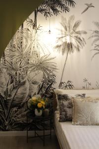 a bedroom with a mural of palm trees on the wall at B&B Les Lumières in Salerno