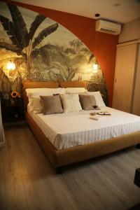 a bedroom with a large bed with a painting on the wall at B&B Les Lumières in Salerno
