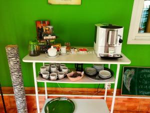 un mur vert avec une étagère avec des tasses et une cafetière dans l'établissement Villa Ostmala, à Ventspils