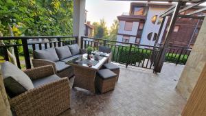 un patio con sedie in vimini e un tavolo sul balcone. di Eve Santa Marina Apartments - sea, pools, relax a Sozopol