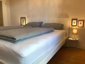 una camera da letto con un letto bianco e una luce sopra di Luther20 a Insheim
