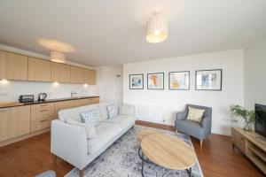 a living room with a couch and two chairs and a table at At The Links in Carnoustie