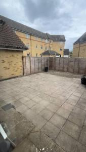 an empty courtyard with a fence and a building at ◑4 Bed Townhouse◑10guests◑ Garden◑Wifi & Netflix◑ in Thamesmead