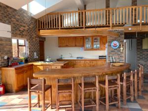 eine Küche mit einem großen Holztisch und Stühlen in der Unterkunft Net Net Holiday Home in Witsand