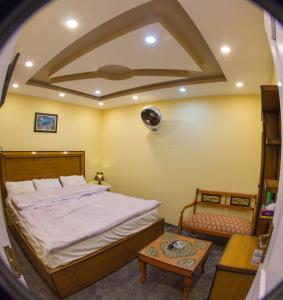 a bedroom with a large bed and a table at Ringchan Guest House & Restaurant in Skardu